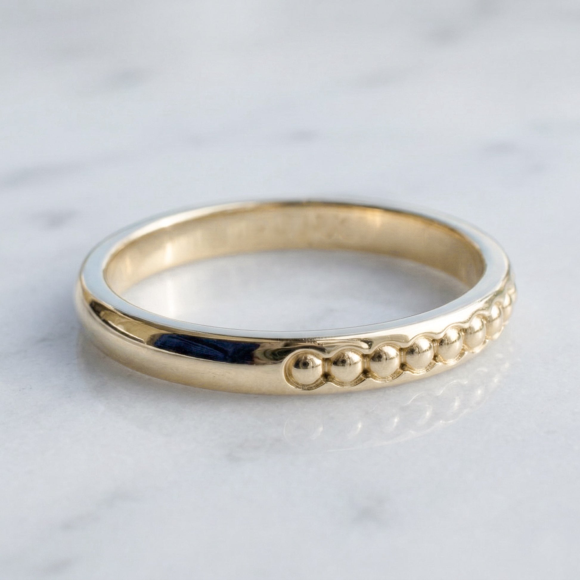 Gold band with spheres in relief 