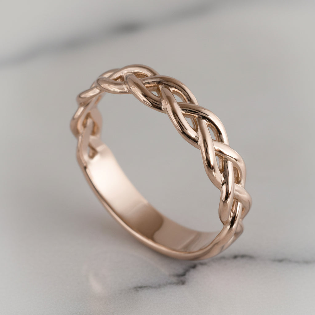 Rose gold braided ring on a marble surface