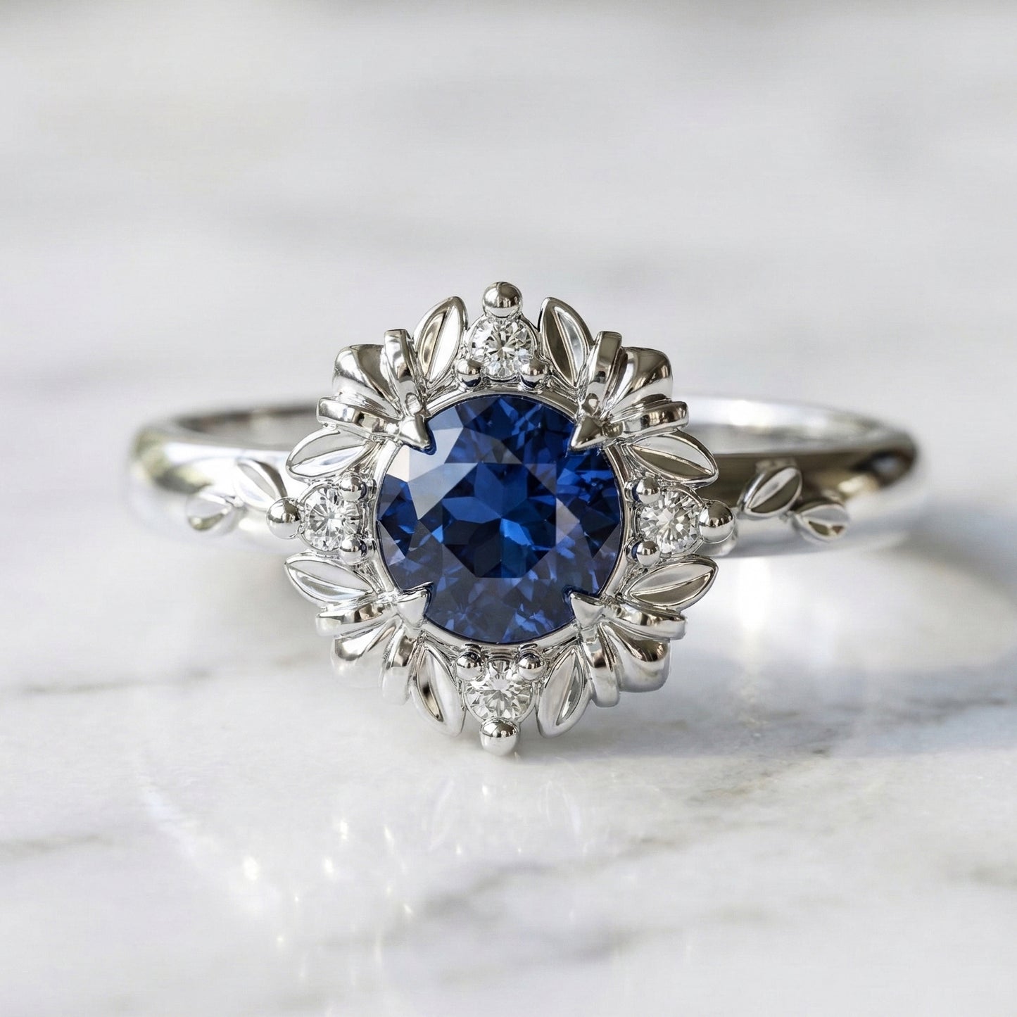 Blue sapphire engagement ring with leaf and diamond halo setting