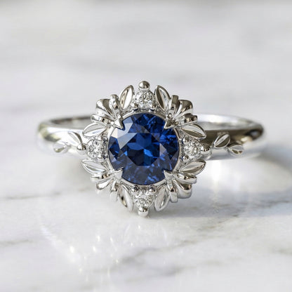 Blue sapphire engagement ring with leaf and diamond halo setting