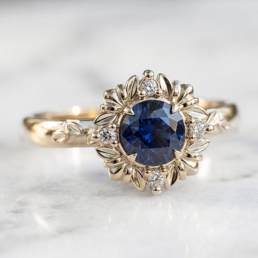 Gold ring with a blue gemstone and diamond accents on a light background