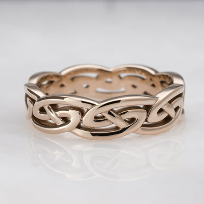 Rose gold Celtic knot ring on a light gray background