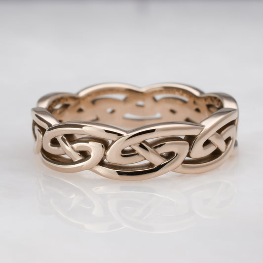Rose gold Celtic knot ring on a light gray background