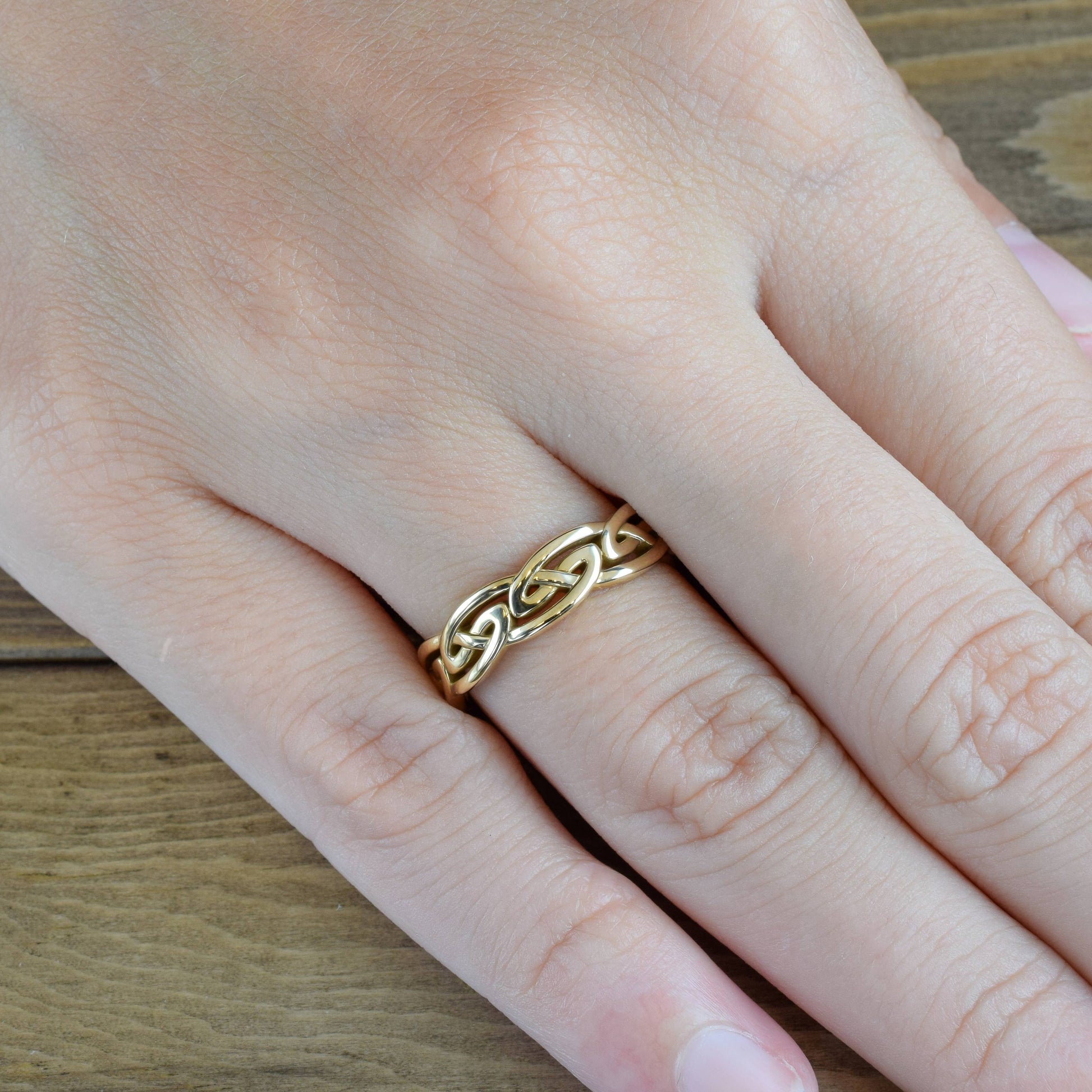 celtic-eternal-knot-ring-in-yellow-gold-on-finger