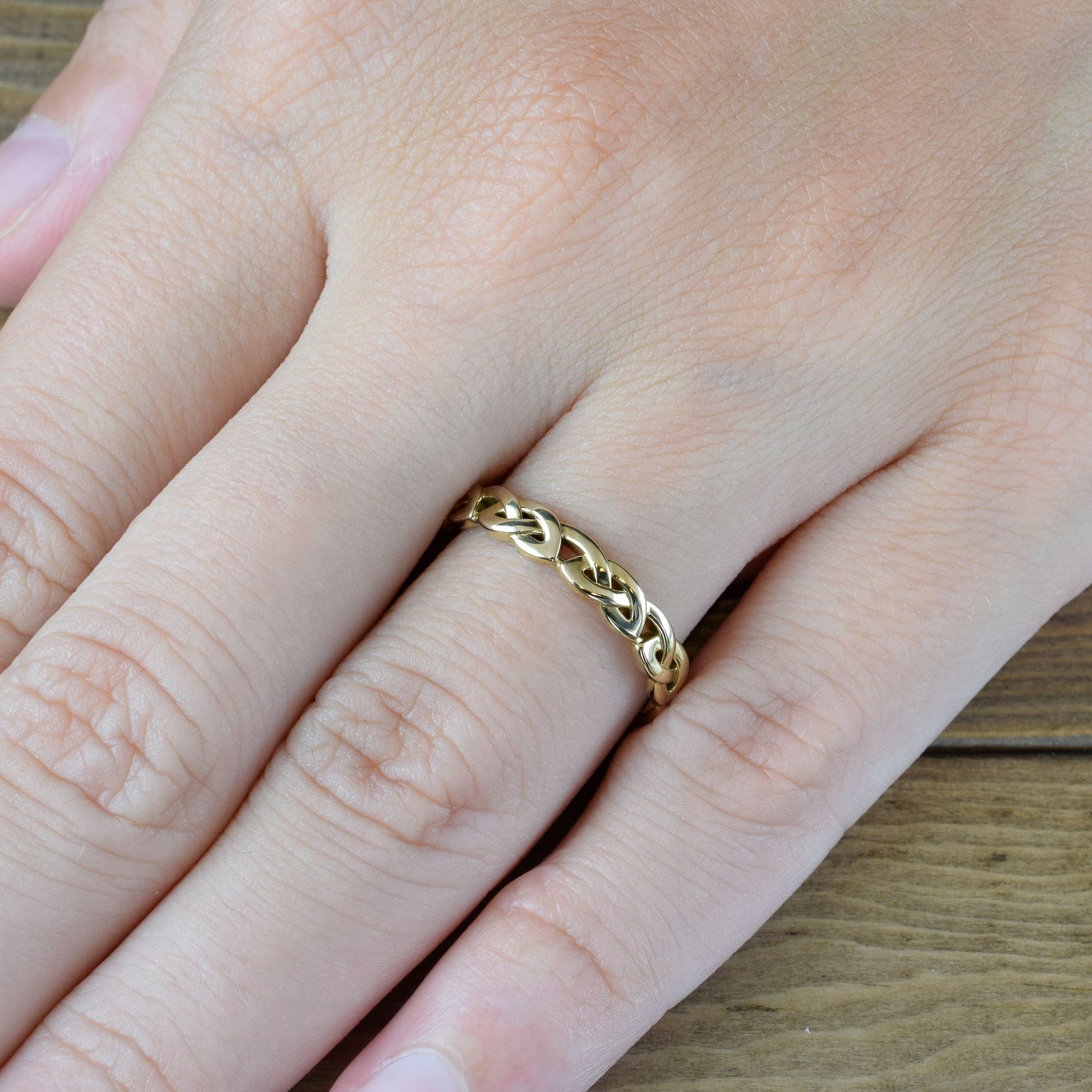 overhand knot eternity ring in yellow gold on finger
