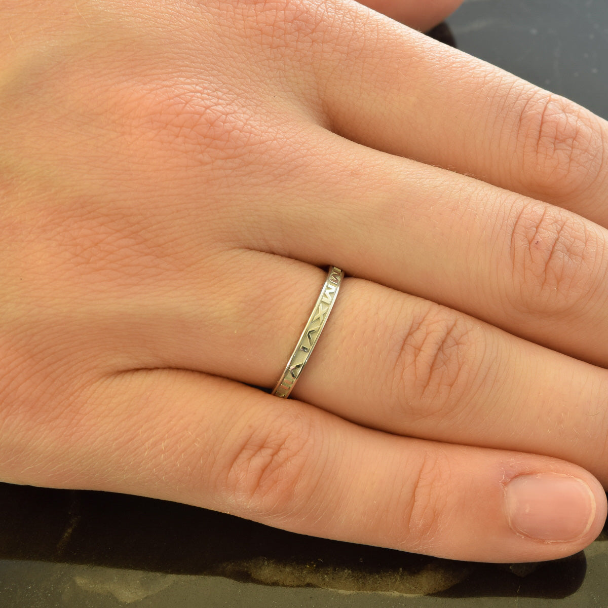 Custom date ring in 14k white gold featuring your date in Roman Numerals, shown on finger