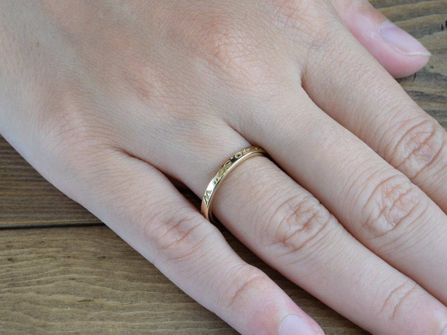 narrow custom engraved coordinates ring in yellow gold on finger