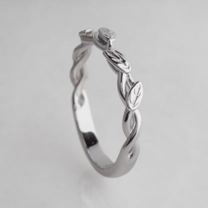 white gold  ring with leaf design on a light gray background