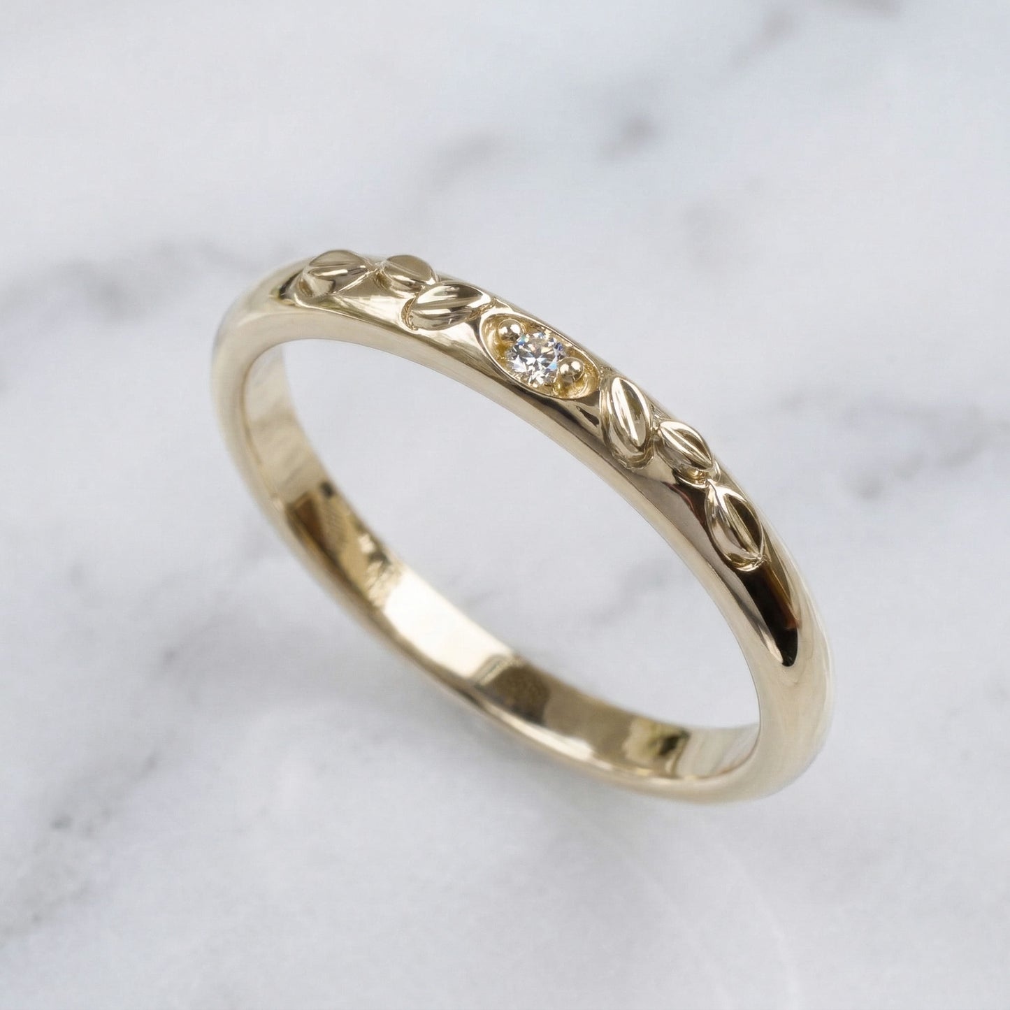 Gold ring with intricate design on a marble surface