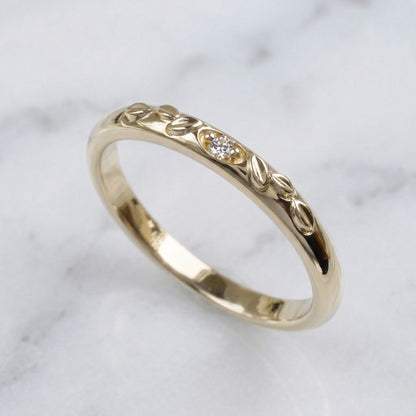 Gold ring with intricate design on a marble surface
