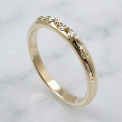 Gold ring with intricate design on a light gray background