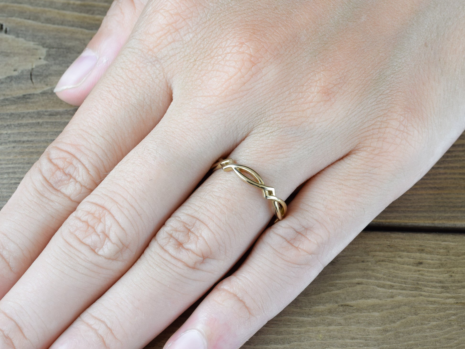 Woven gold band - A Celtic ring in yellow gold on finger