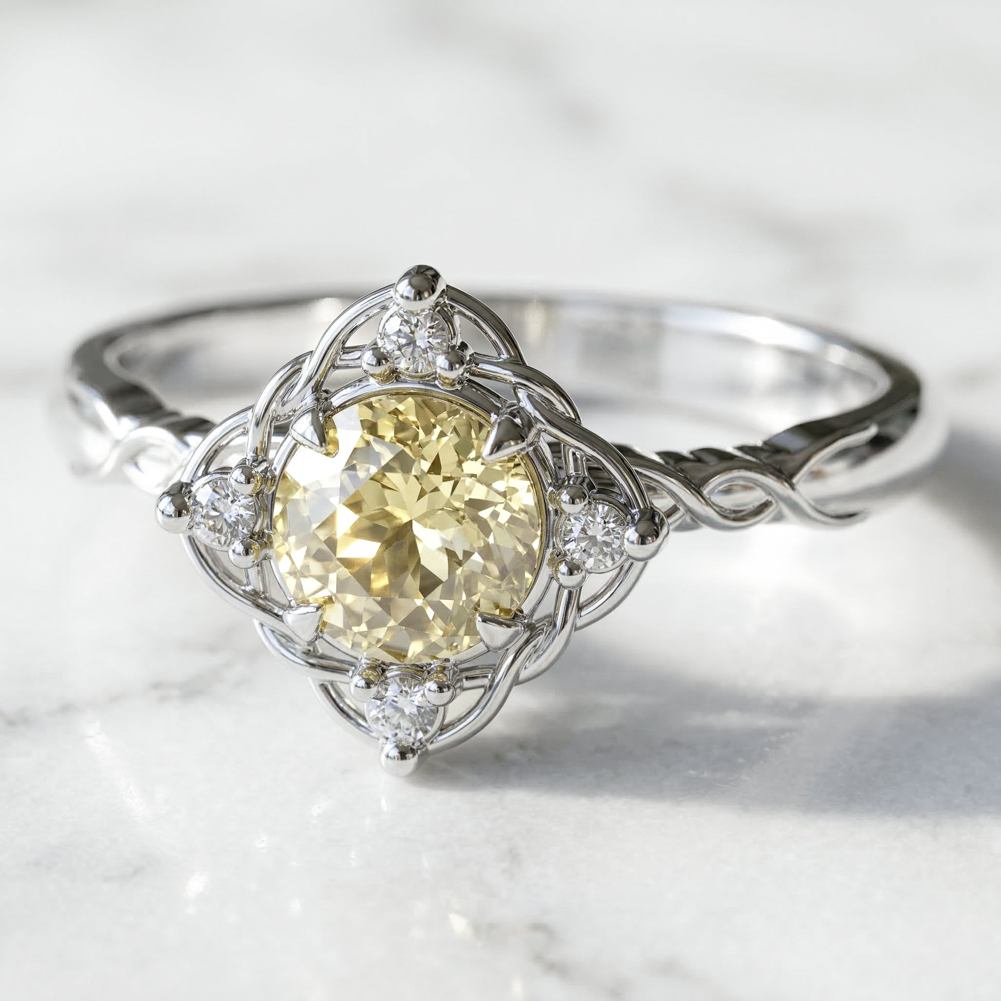 A round engagement ring with a central lab-created light yellow sapphire gemstone, flanked by four small lab-created diamonds, all set in a white gold band.